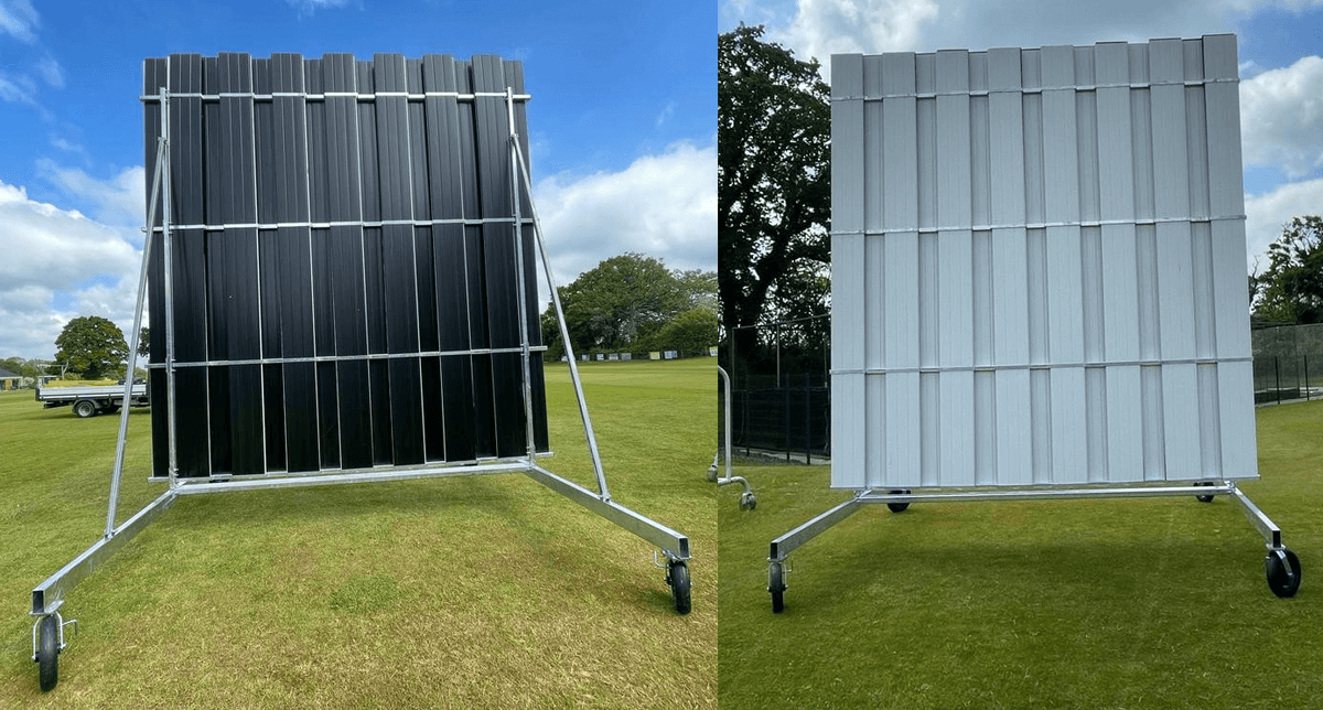 4.5M High X 4M Wide Black And White Swivel Sight Screen on a field with grass and trees in the background.