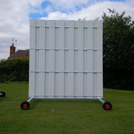 4.5M High X 4M Wide Sight Screen on grass with wheels and cloudy sky in background.