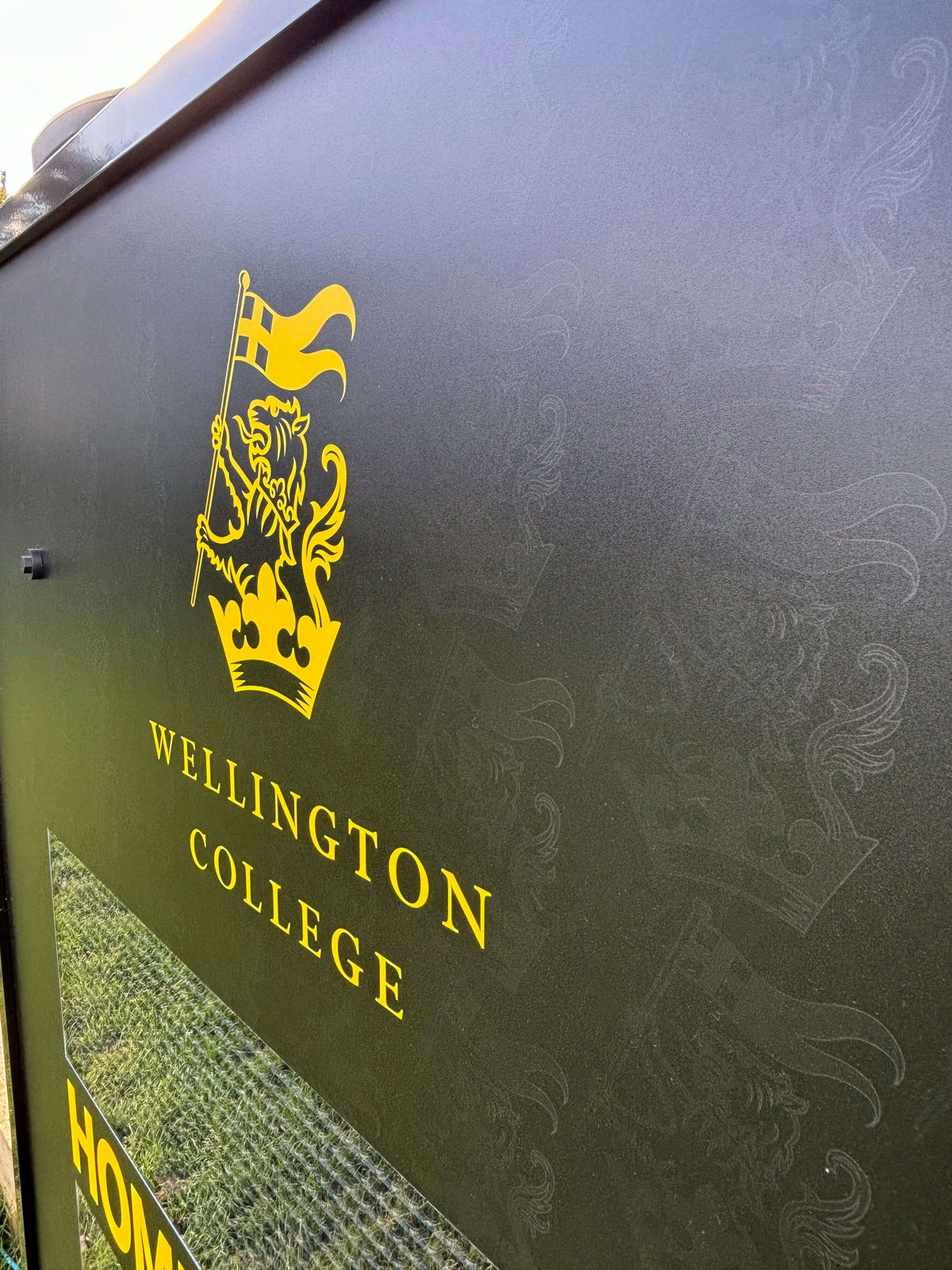 Wellington College scoreboard featuring bright yellow lion logo and clear visibility for home/away display.